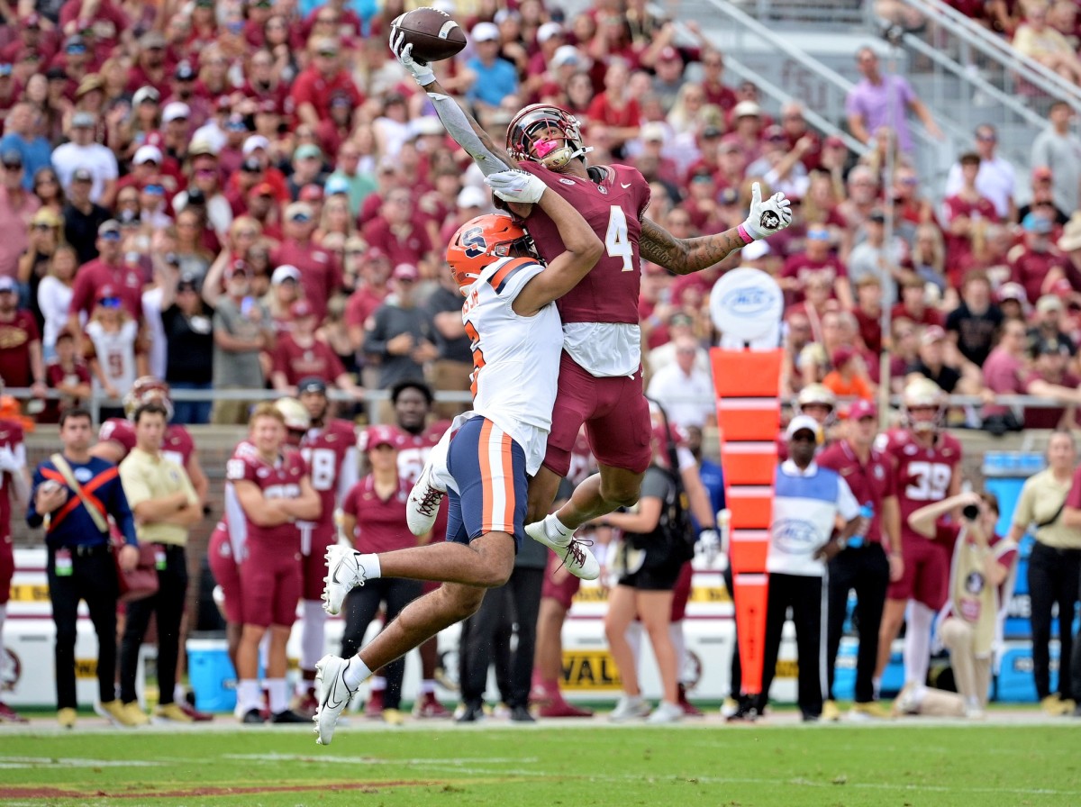 Oct 14, 2023; Tallahassee, Florida, USA; Florida State Seminoles wide receiver Keon Coleman (4) catches a pass over Syracuse Orange defensive back Jason Simmons Jr. (6) during the first quarter at Doak S. Campbell Stadium. Mandatory Credit: Melina Myers-USA TODAY Sports  
